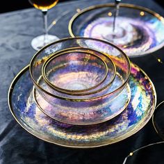 there are four glass plates on the table with wine glasses in front of each plate