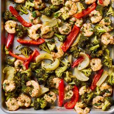 a tray filled with shrimp, broccoli and red peppers on top of it