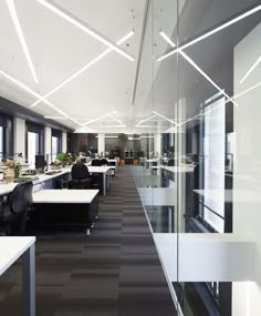 an office with black and white checkered flooring, large windows, and desks