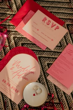 the wedding stationery is laid out on top of each other, including two rings