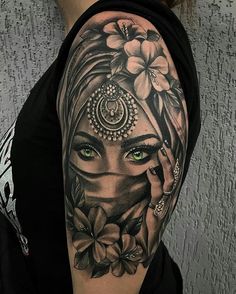 a woman's face with green eyes and flowers on her arm