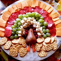 a turkey shaped platter with crackers, grapes, and cheeses on it