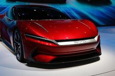 a red car is on display at an auto show