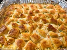 a casserole dish with chicken, cheese and bread toppings in it on a table