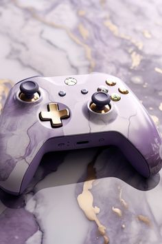 a close up of a game controller on a marble surface with gold and silver accents