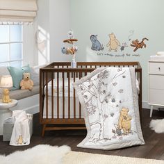 a baby's room with winnie the pooh wall decals and crib bedding