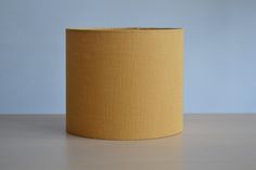 a yellow lamp shade sitting on top of a wooden table