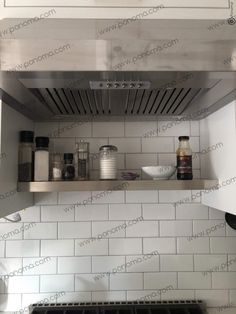 a stove top oven sitting inside of a kitchen next to a wall mounted range hood