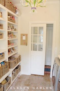 a laundry room with baskets on the floor and shelves full of items in front of it