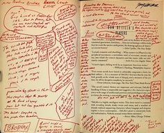 an open book with writing on the pages and handwritten notes in red ink over black paper