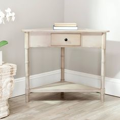 a white table with two drawers and a plant