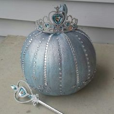 a blue ball with a tiara on it next to a pair of tongs