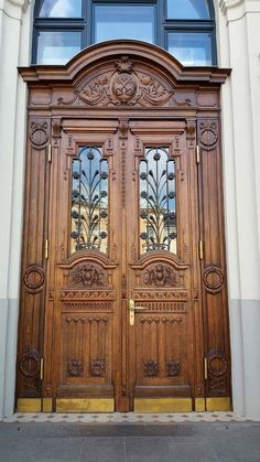 an ornate wooden door with glass panes on the front and side windows above it