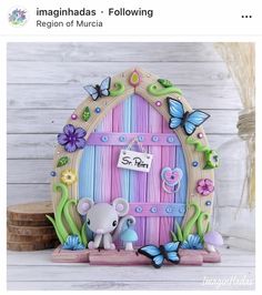 an image of a small door with a mouse and flowers on the front, and butterflies around it