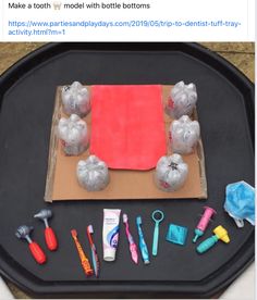 an image of some toys on top of a black tray with red paper and other items