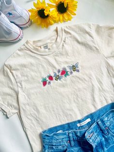 For strawberry and bee lovers everywhere, this Strawberries and Bees Embroidered Crewneck T-shirt is the perfect addition to your wardrobe. With a beautiful design of strawberries and bees with precious flowers embroidered on a Comfort Colors Tee. Flower T Shirt Design, Cute Embroidered T-shirt With Relaxed Fit, Summer Crew Neck T-shirt With Floral Embroidery, Casual Embroidered Graphics T-shirt For Spring, Cute Embroidered T-shirt For Spring, Cute Embroidered Relaxed Fit T-shirt, Cute Crew Neck T-shirt With Custom Embroidery, Casual T-shirt With Multicolor Embroidery And Logo, Cute Floral Embroidery Crew Neck T-shirt