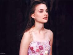 a beautiful young woman in a strapless dress posing for a photo with flowers on it