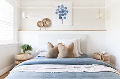 a bed with two pillows on top of it and palm trees above the headboard