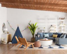 a living room with white walls and wooden floors, decorated in blue and yellow colors