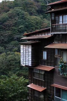 an apartment building with wooden balconies on the balcony and trees in the background