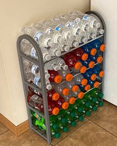 a rack filled with lots of water bottles next to a white wall and tile floor