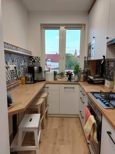 a kitchen with wooden floors and white cabinets