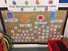 a bulletin board with words and pictures on it in front of some bins filled with toys