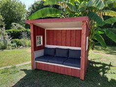 a red and blue couch sitting under a tree