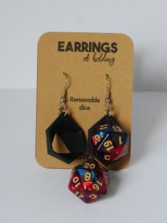 two dice shaped earrings sitting next to each other