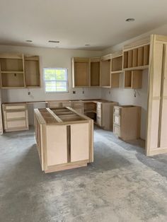 an empty kitchen with unfinished cabinets in it