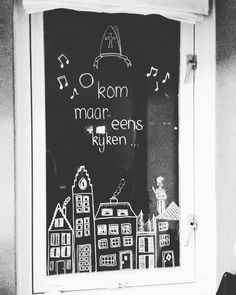 a black and white photo of a window with chalk writing on it that says room madar eens kyken