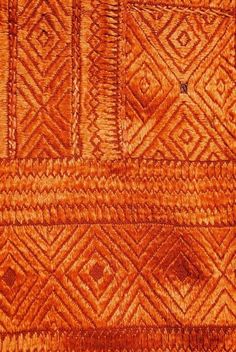 an orange and brown area rug with diamond shapes on it's surface, closeup