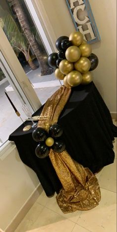 black and gold balloons are on top of a table