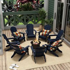 a group of chairs sitting on top of a wooden deck next to a fire pit