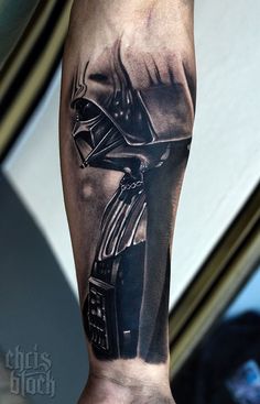 a man's arm with a black and white tattoo on it, featuring a darth vader