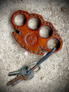 a wooden key holder with four holes in the middle and two keys attached to it