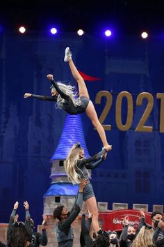 two women doing acrobatic tricks in front of a crowd