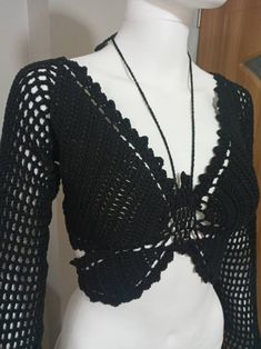 a white mannequin wearing a black crochet top