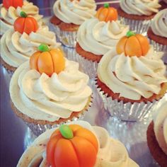 cupcakes with white frosting and pumpkin decorations