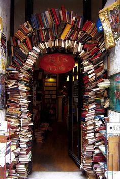 an arch made out of books is shown in the doorway to a book store filled with books