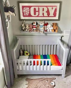 a baby crib with stuffed animals on the top shelf, and a sign that says the cry above it