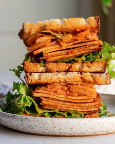 a stack of sandwiches sitting on top of a white plate