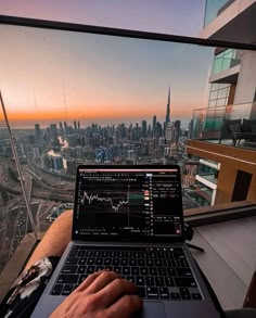 a man sitting in front of a laptop computer on top of a building