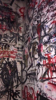 the wall is covered in graffiti and has many different types of writing all over it