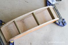 three pieces of wood sitting on top of a floor next to pliers and other tools