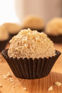 a close up of a cupcake on a wooden table with text overlay that reads white chocolate brigadero