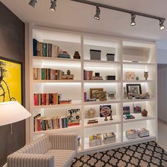 a living room filled with lots of furniture and bookshelves covered in white shelves