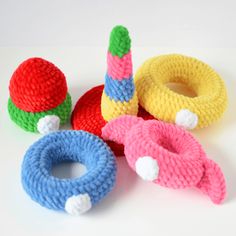 knitted toys sitting on top of a white table next to each other in different colors