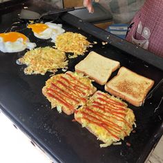 toasted eggs and hash browns are being prepared on a grill