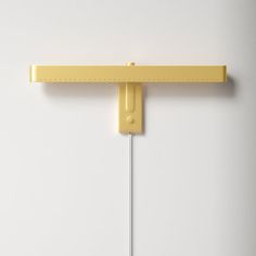 a yellow wall mounted light on a white wall